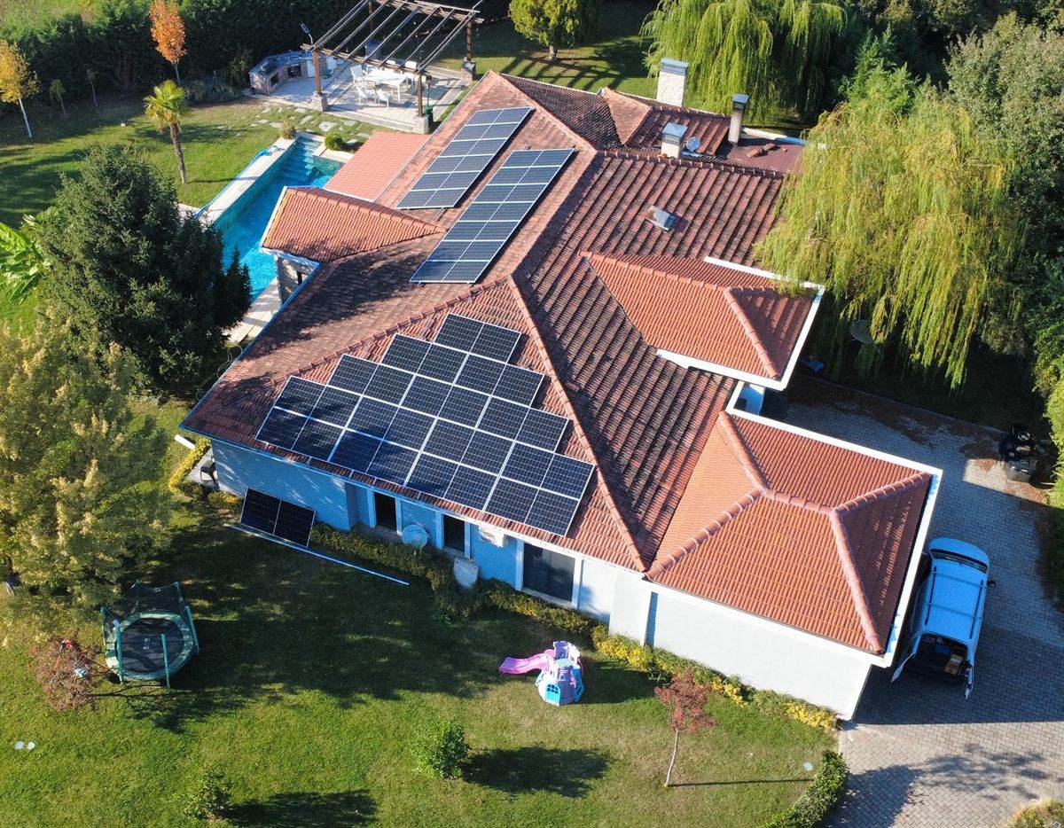 Havuzlu müstakil villanın çatısına kurulu güneş enerjisi sistemi, drone görüntüsü